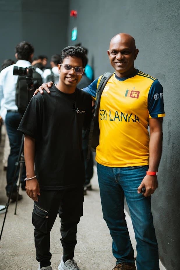 Two attendees smiling in the hallway, one in a Sri Lanka cricket jersey