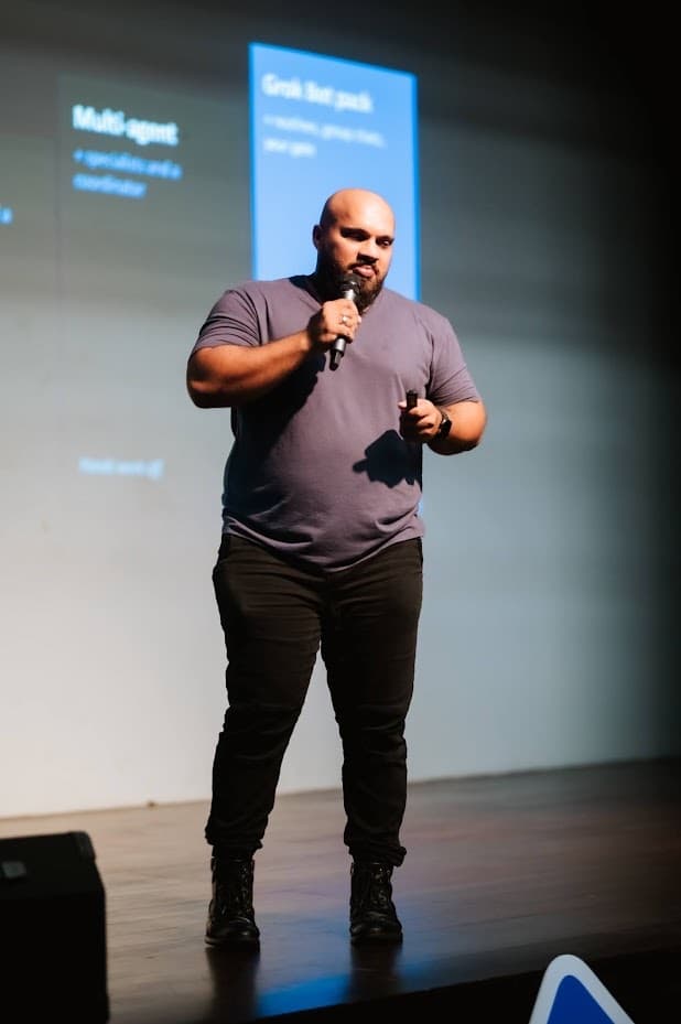 Speaker presenting multi-agent Grok Bot setups on stage at DHPL Auditorium