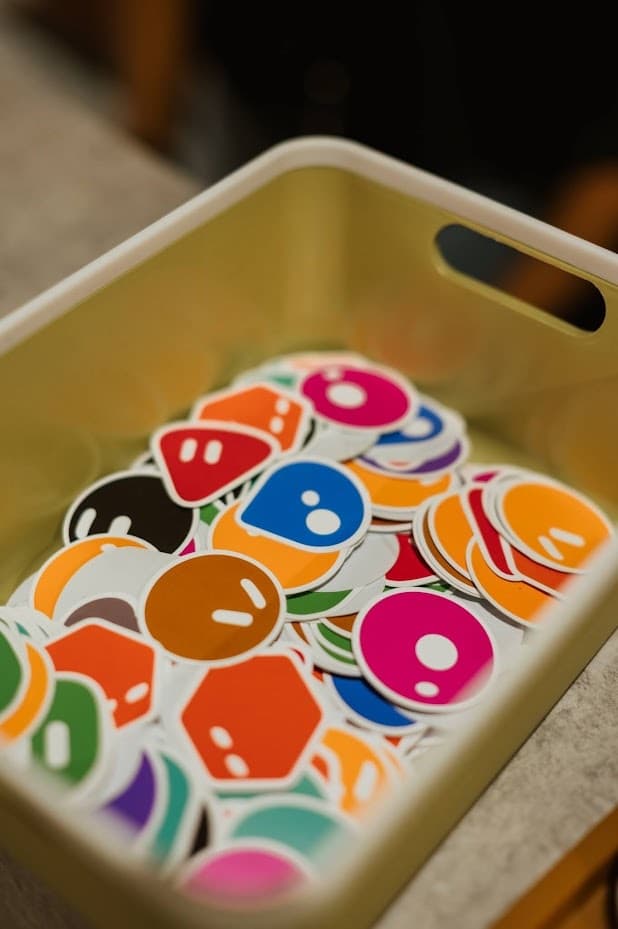 A tub of colourful Grok Bot character stickers